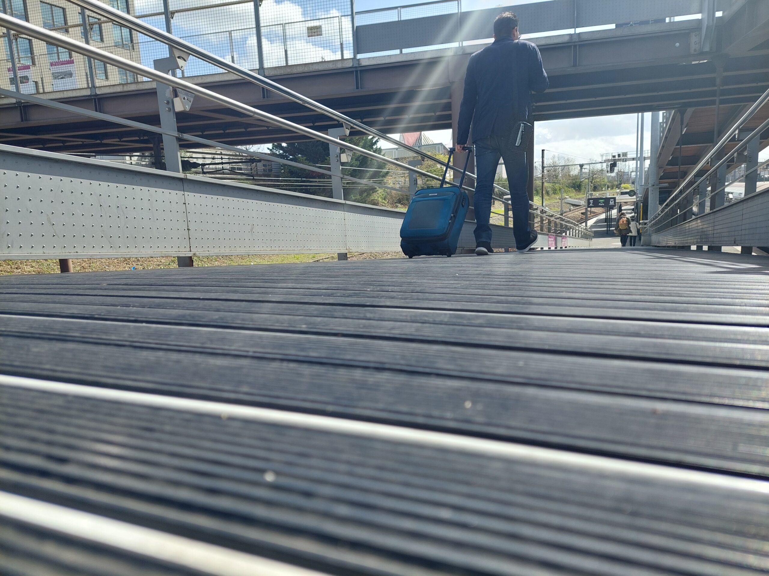 RUBBY by BORFLEX flooring in a station; a pedestrian is walking across it carrying a suitcase